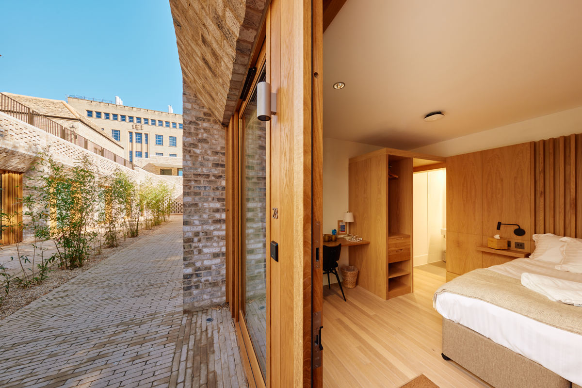 Rhodes House accommodation - View of courtyard bedroom through the open door.