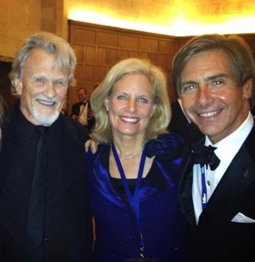 Elliot stood to the right of two friends, all in formal attire, smiling.
