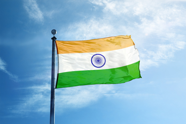 An image of the Indian flag unfurled against a blue sky