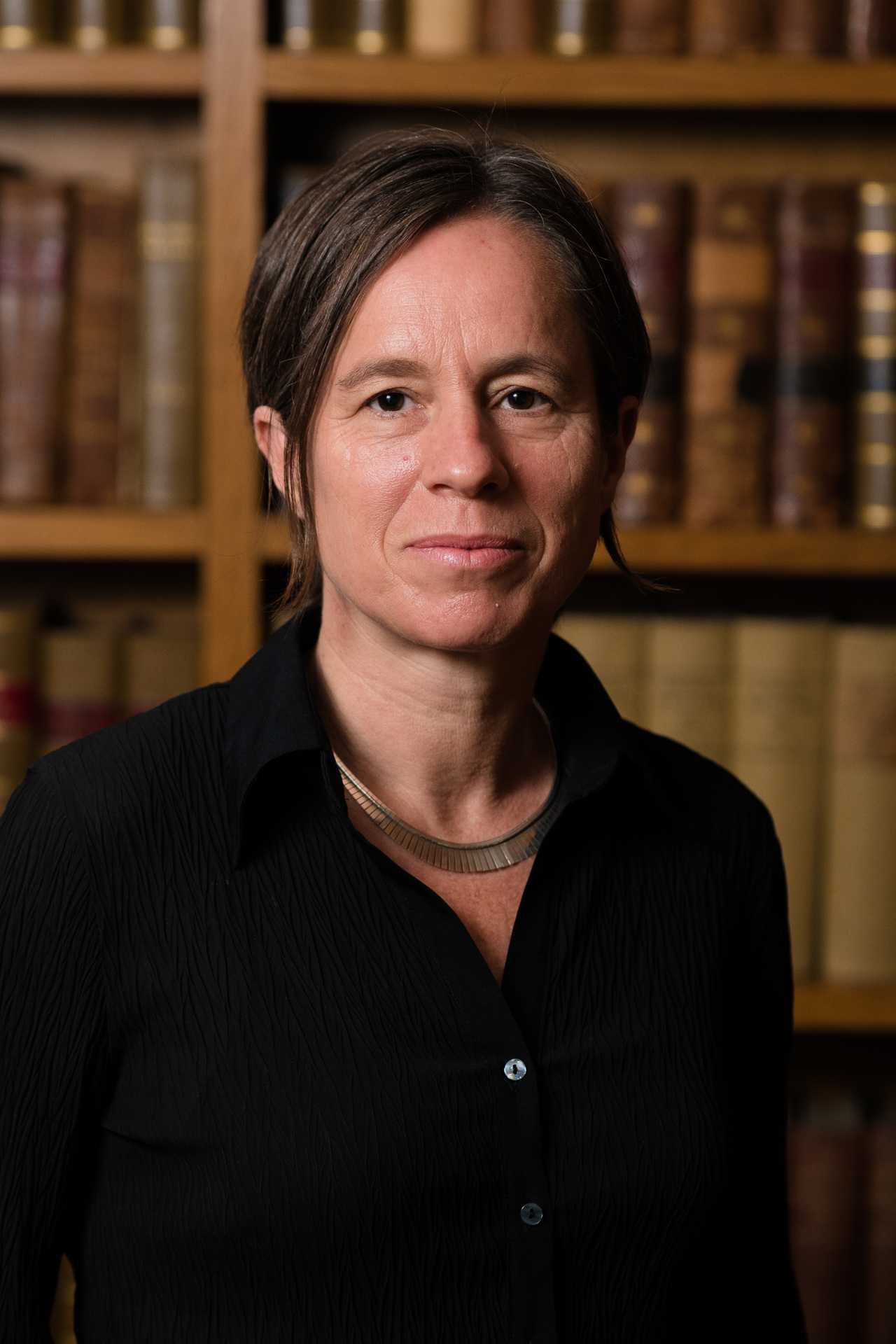 Formal portrait of Cecile wearing a black shirt and looking into the camera.