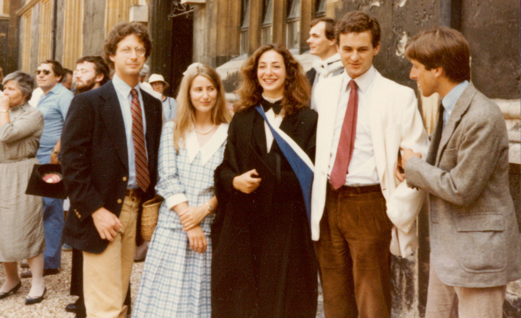 A picture showing a group of people with Jessica in the middle in a graduation gown 