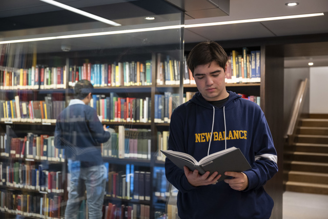 Scholar holding a book open and reading
