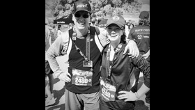 Charles and Sarah with hats on and stickers on their t-shirts as part of a half marathon