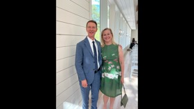 Bob in a blue suit with his wife in a green dress