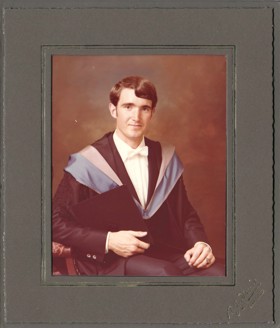 A framed photograph of John in a graduation gown