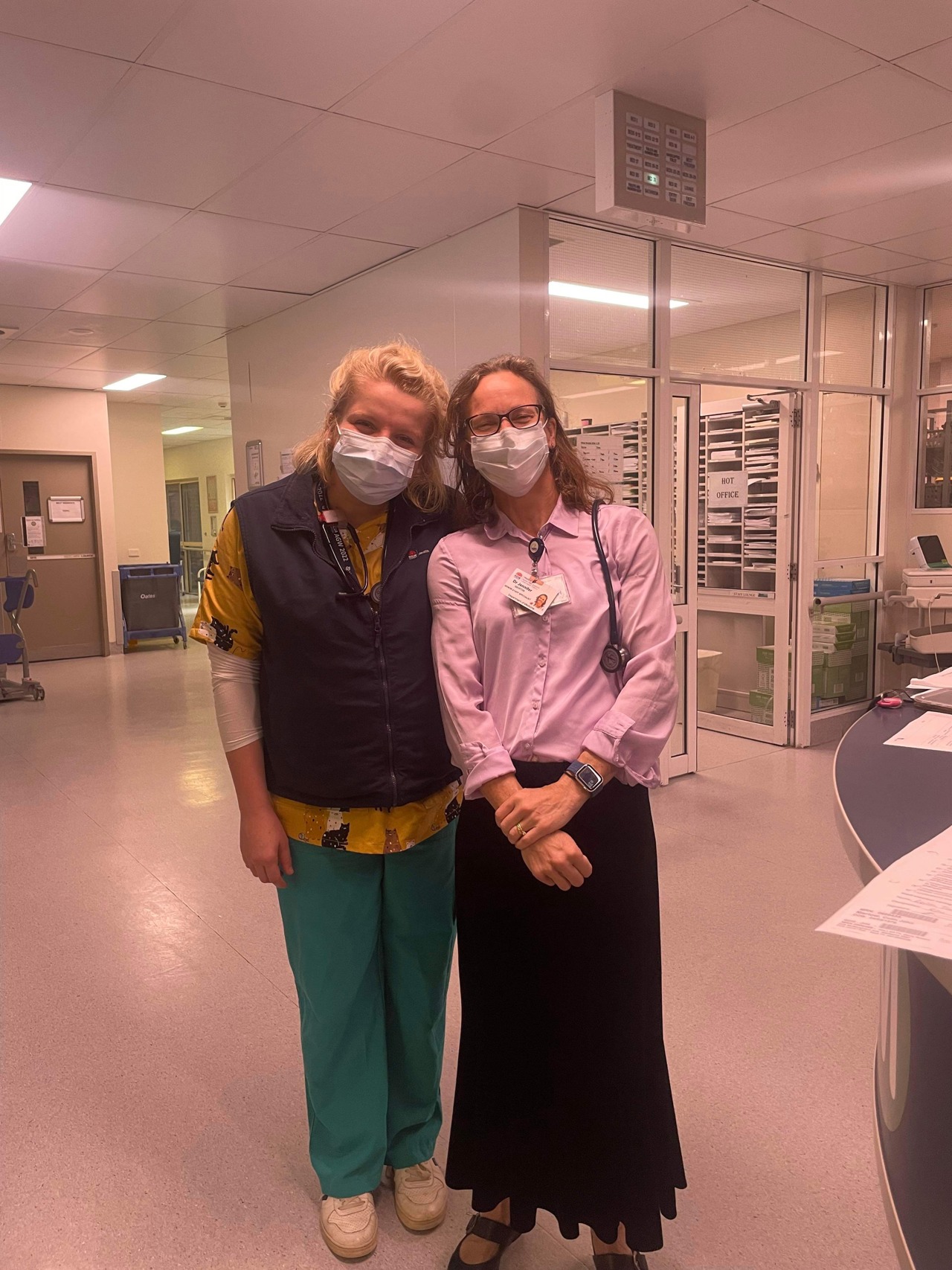 Jenny stood with a fellow colleague in a hospital ward both wearing masks.