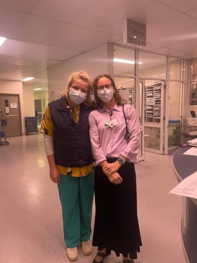 Jenny stood with a fellow colleague in a hospital ward both wearing masks.