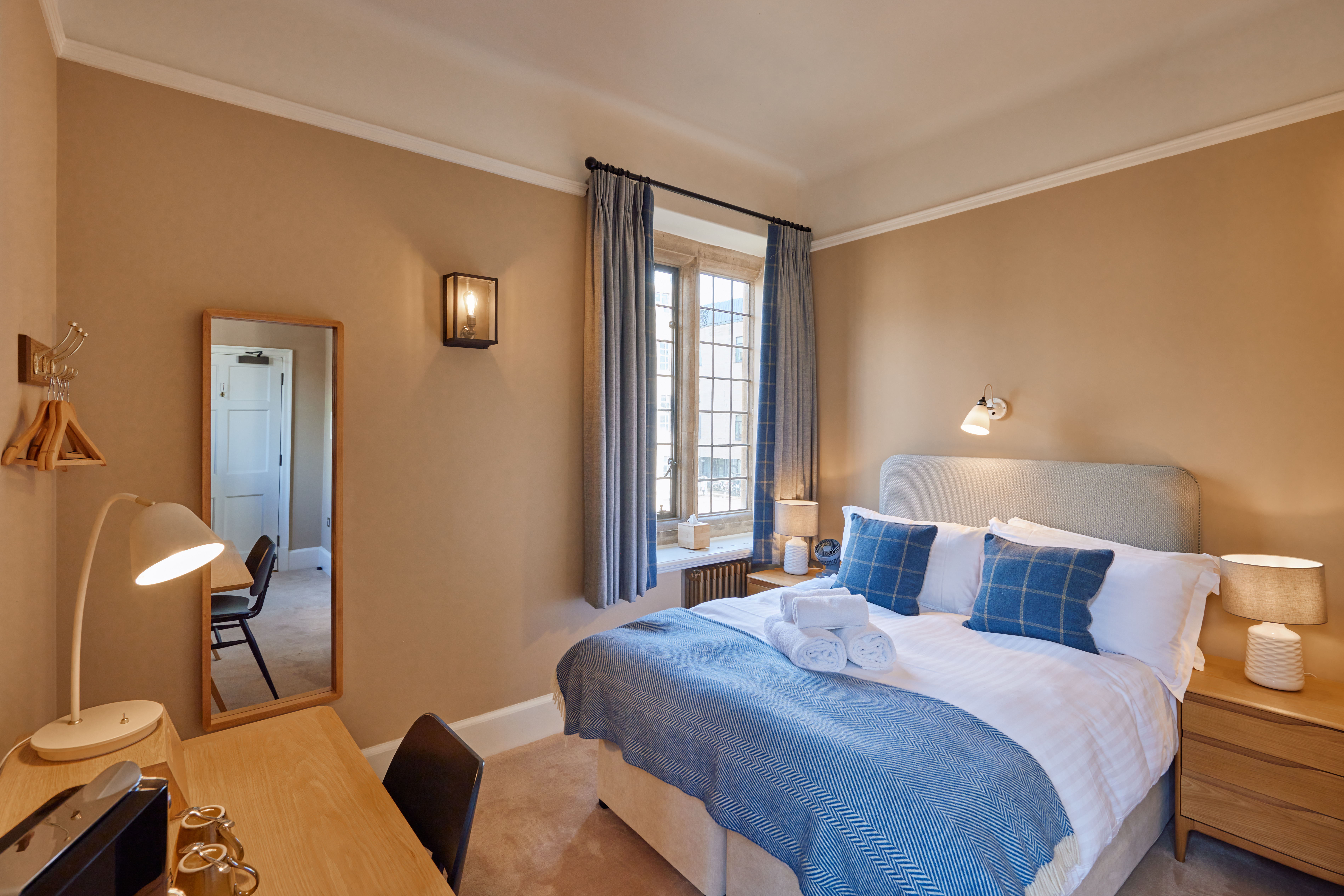 Rhodes House accommodation - double bedroom with blue soft furnishings and beige walls. 