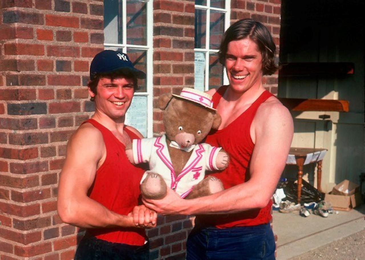 Nick and captain stood smiling and holding a fluffy bear mascot.