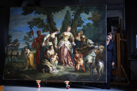 Jaynie stands next to a huge painting depicting the finding of a baby Moses by a group of women.
