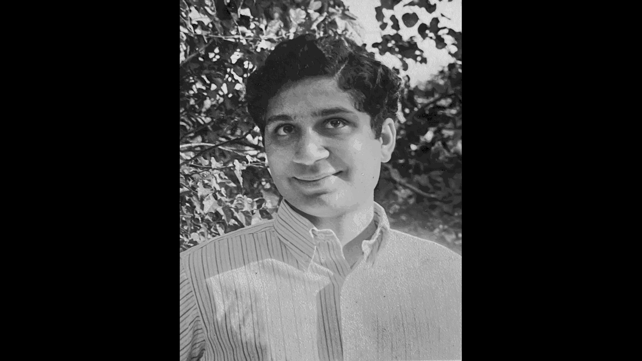 A black-and-white picture of Deepak with leaves in background