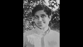 A black-and-white picture of Deepak with leaves in background
