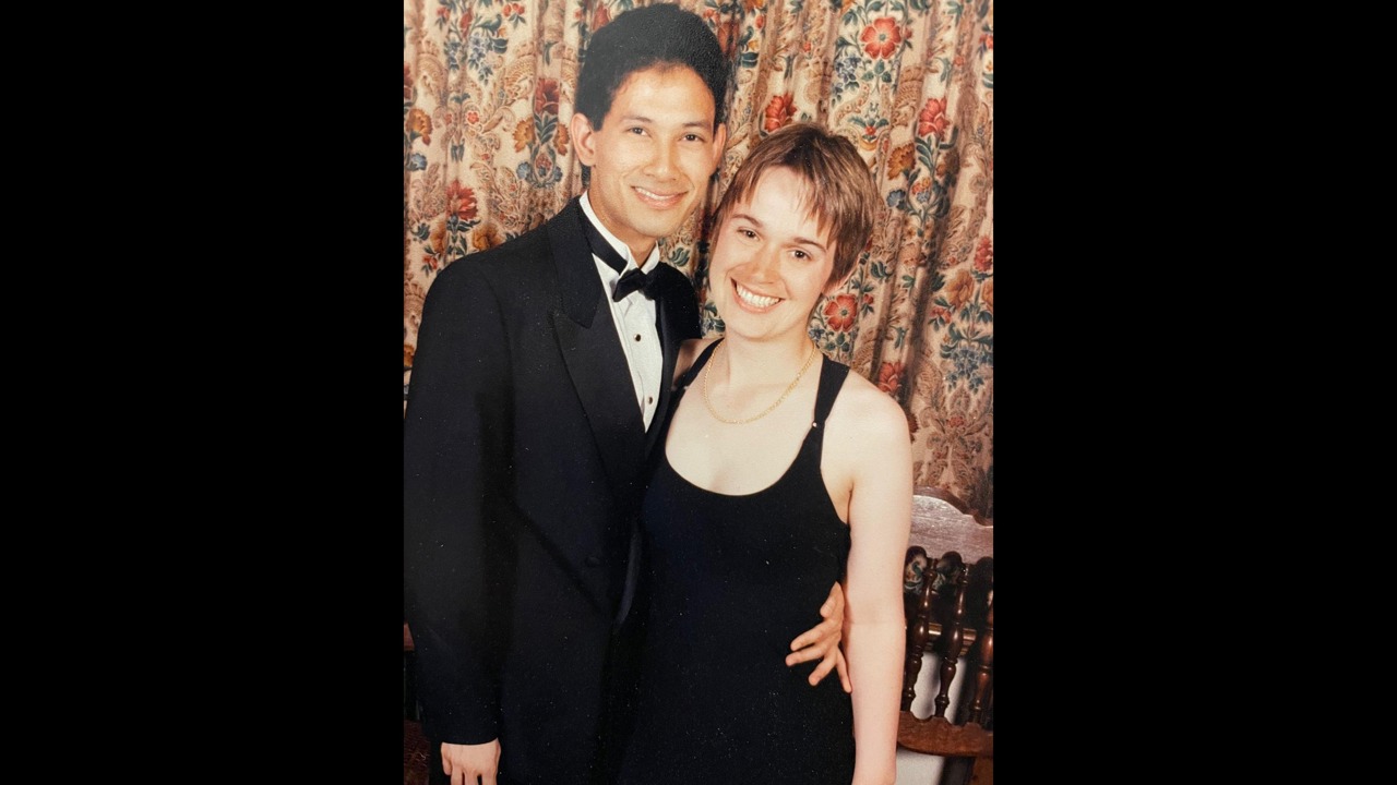 A picture showing a young Elle in a dress with Roger Arjoon standing with her in a suit