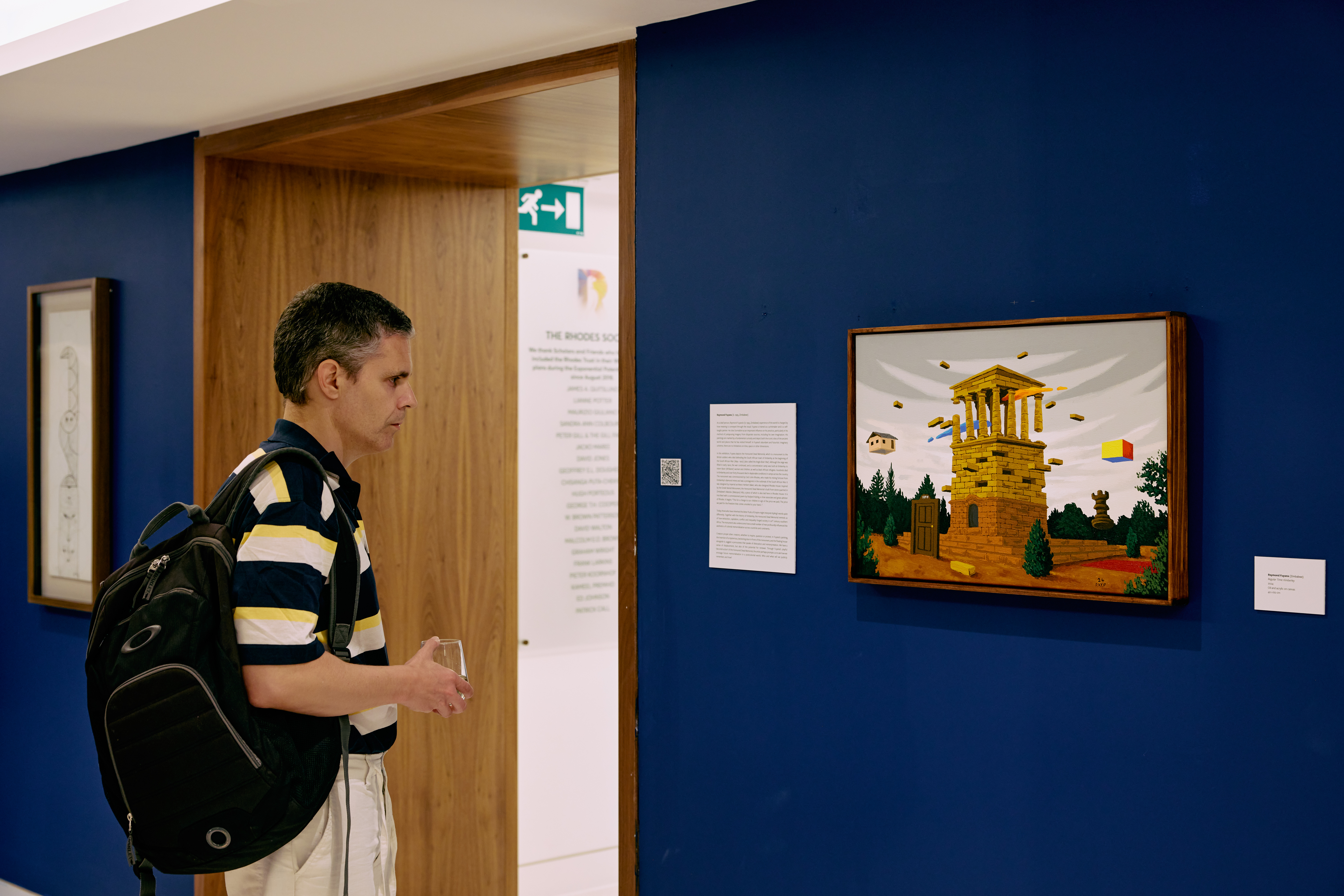 A man viewing the artwork titled Regular Time: Kimberley by Raymond Fuyana