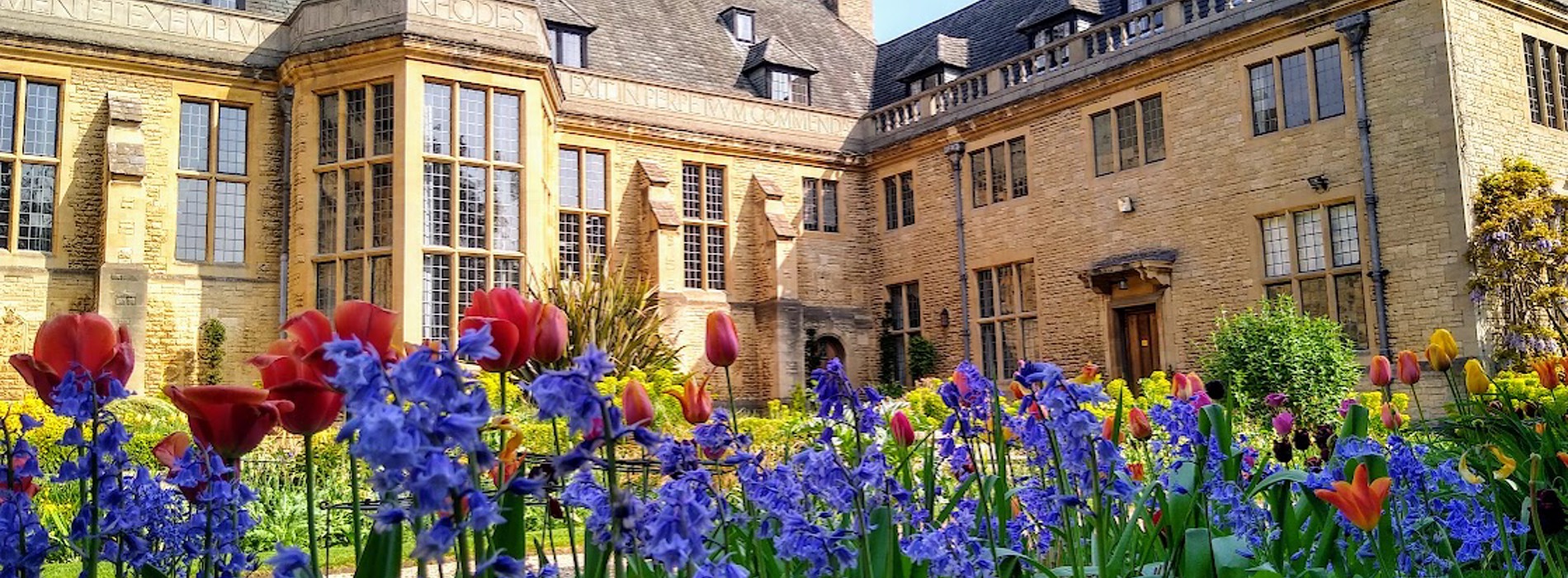 Spring flower border with the back of Rhodes House in the background.