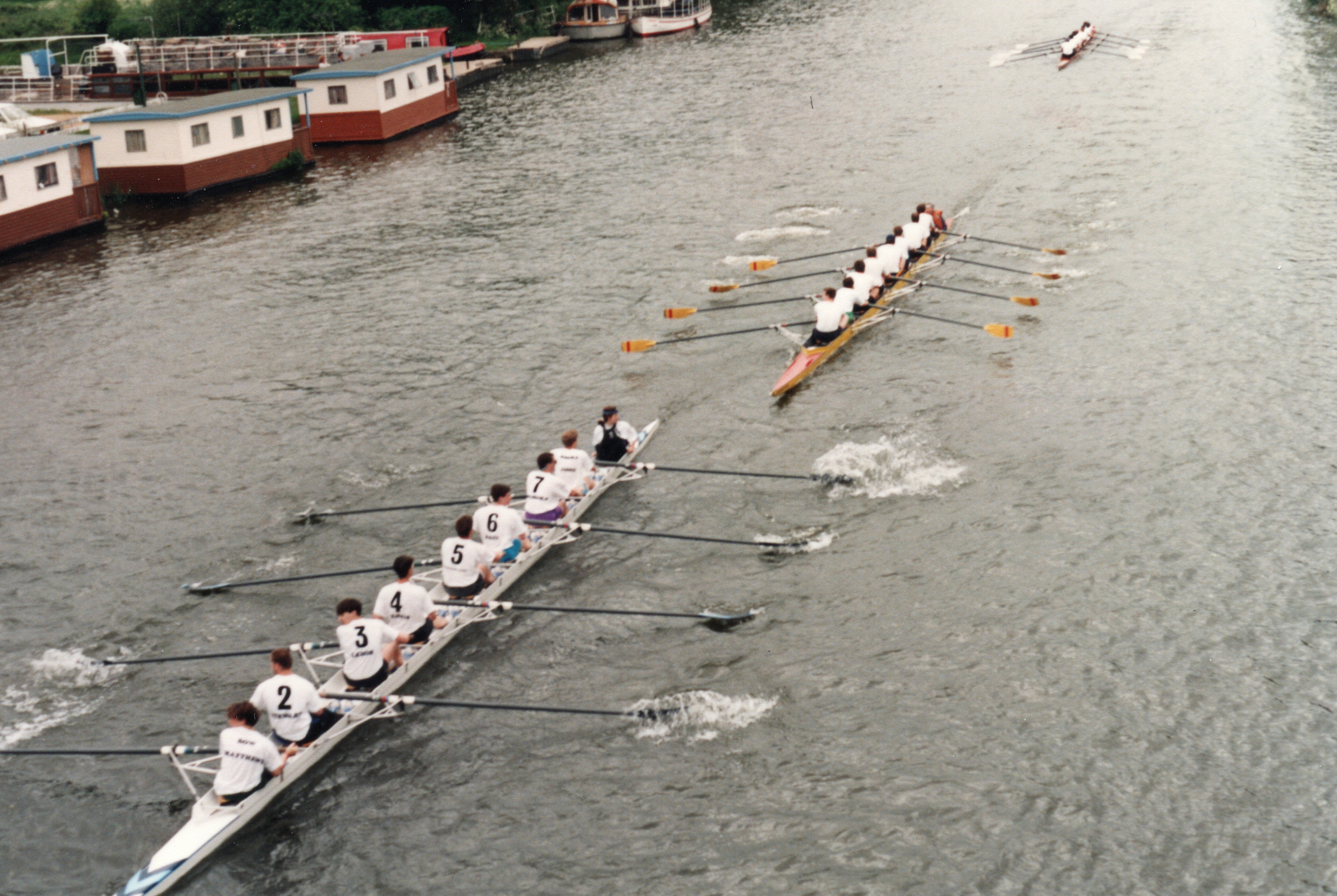 Birds eye photo of the Wolfson rowing team. 3 rowing boats are seen racing.