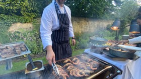 Chef grilling shrimp outside on the BBQ for a Rhodes House event.