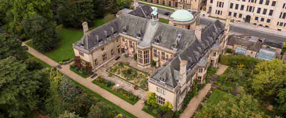 Rhodes House seen from the air with green gardens surrounding
