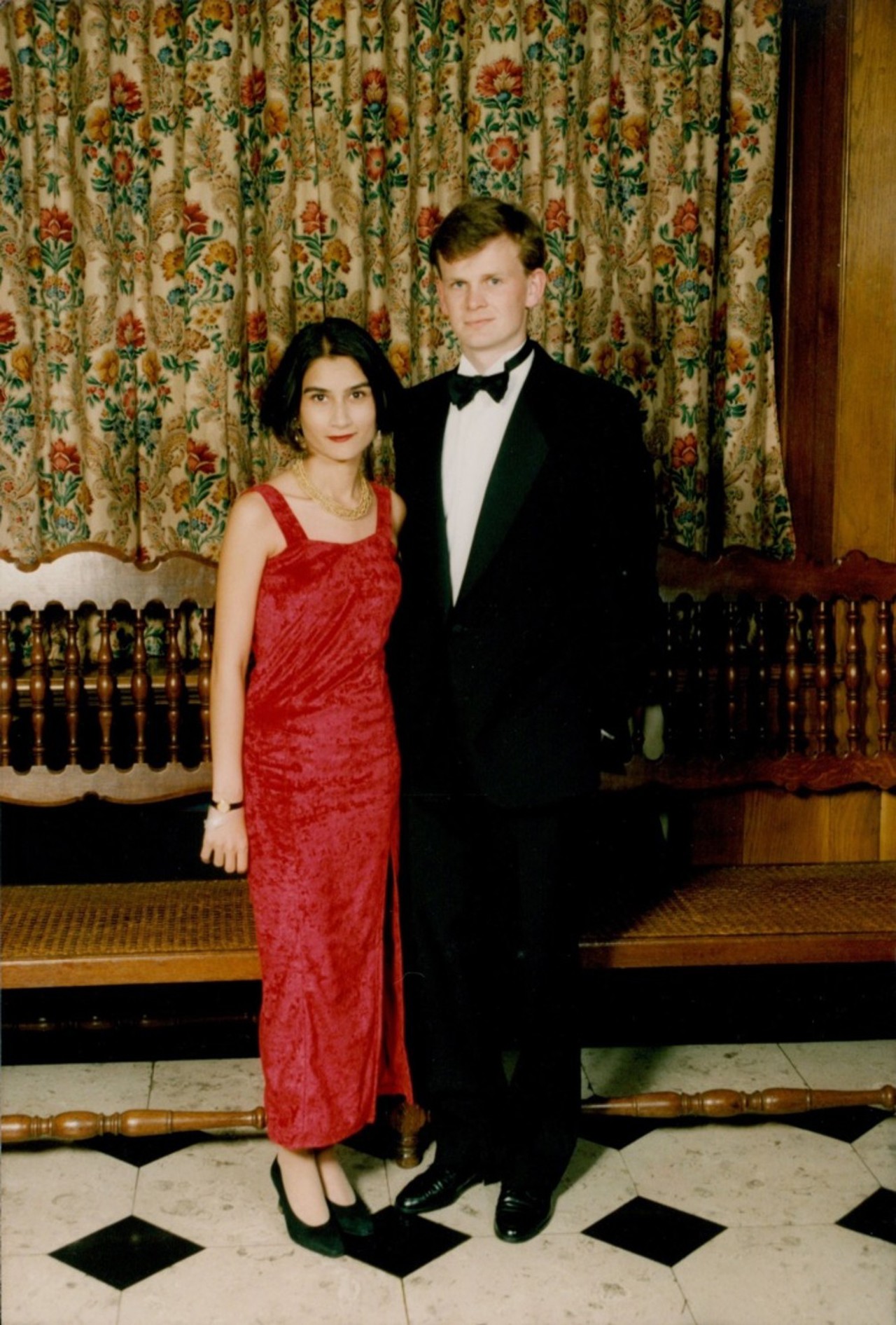 The picture shows Mark in a black suit. Standing next to him is a young woman in a red dress.