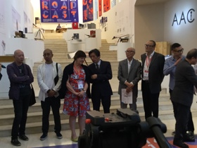 Jaynie standing with a group of people who are wearing suits