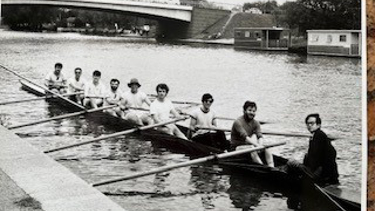 A black-and-white picture showing a group of people rowing.
