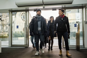 Three Scholars walking through on open doorway