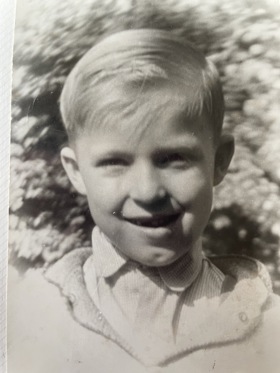 Black and white photo of Geza smiling as a young boy.