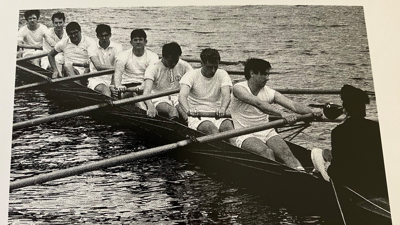 A black-and-white picture of people rowning.