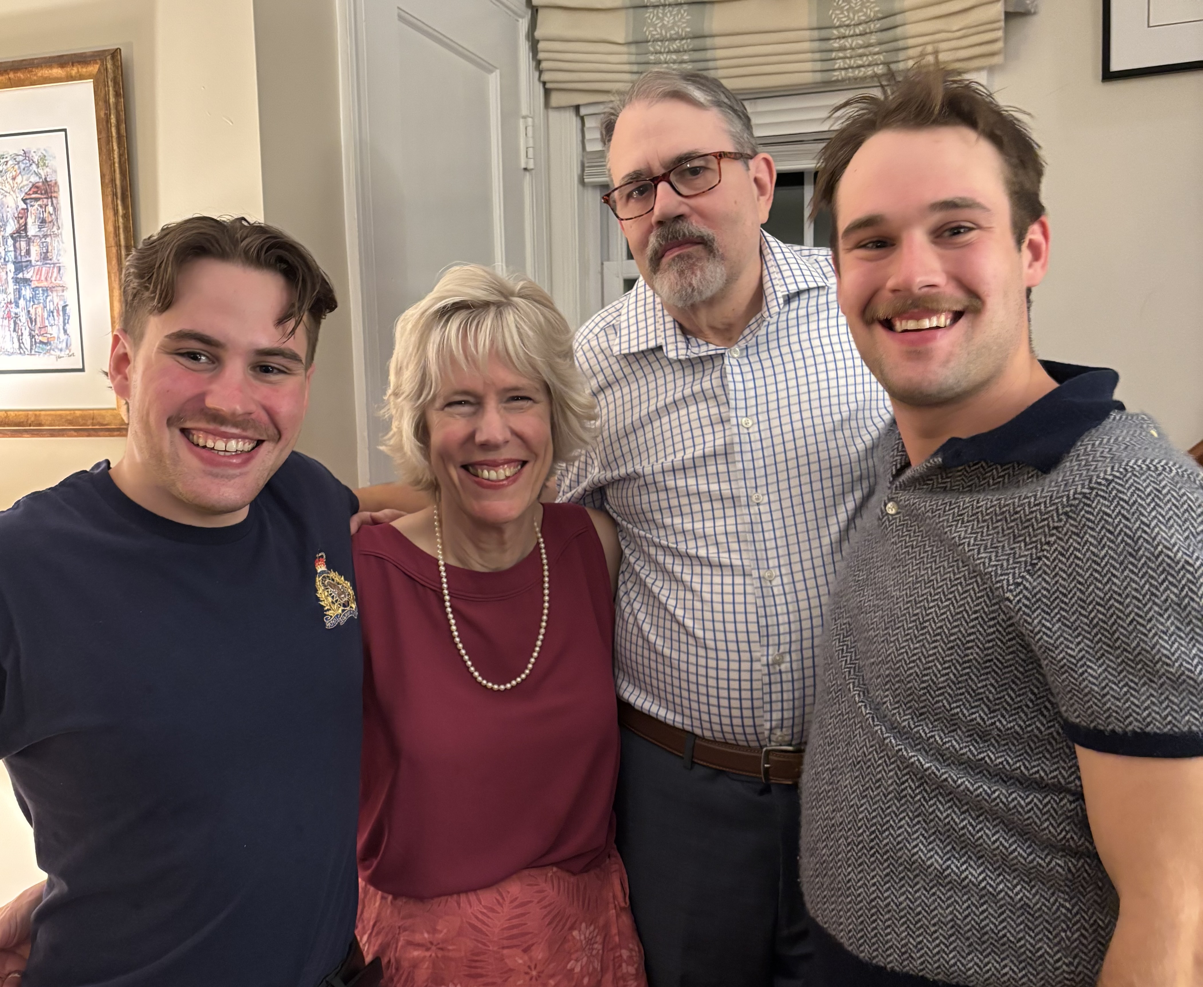 eredith's sons are pictured standing either side of Meredith and her husband. 