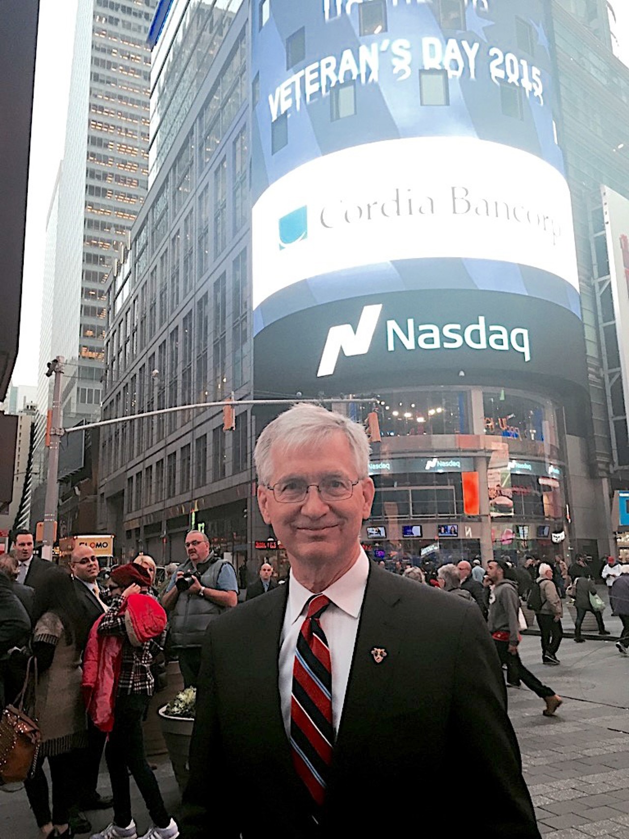 A picture of Jack in a suit. Behind him is a screen on which is advertised 'ComFed Bancorp'.