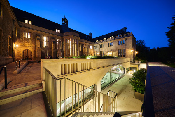 View of the Courtyard at night with lights coming from the windows and steps leading to the Conference Hall below.