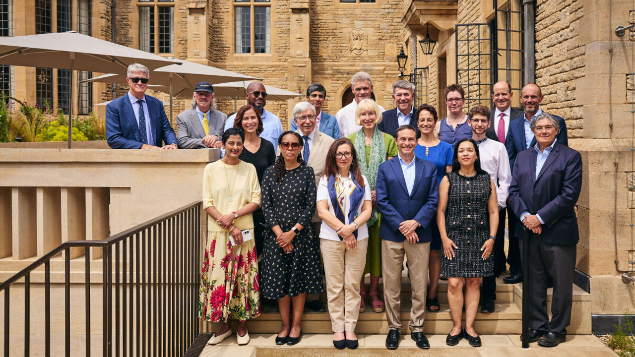 Group photo of Rhodes Trustees and guests standing next to translation stones for the new and old inscriptions