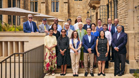 Group photo of Rhodes Trustees and guests standing next to translation stones for the new and old inscriptions