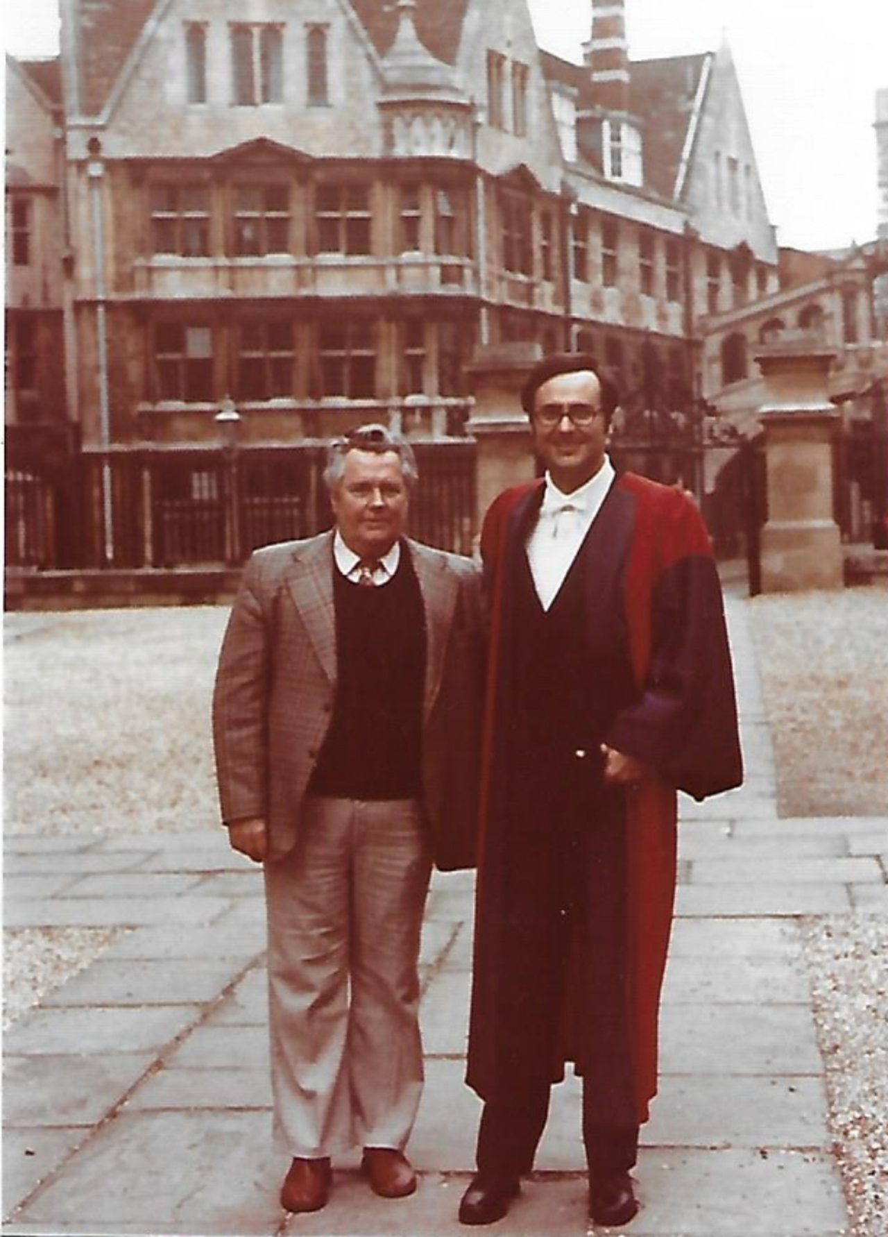 The picture shows Jim in a graduation gown with Hertford College and the Bridge of Sighs in the background. Jim's father is in a suit and is standing next to him.