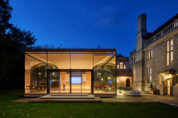 View of the Glass Pavilion at night from the garden with Rhodes House to the right.