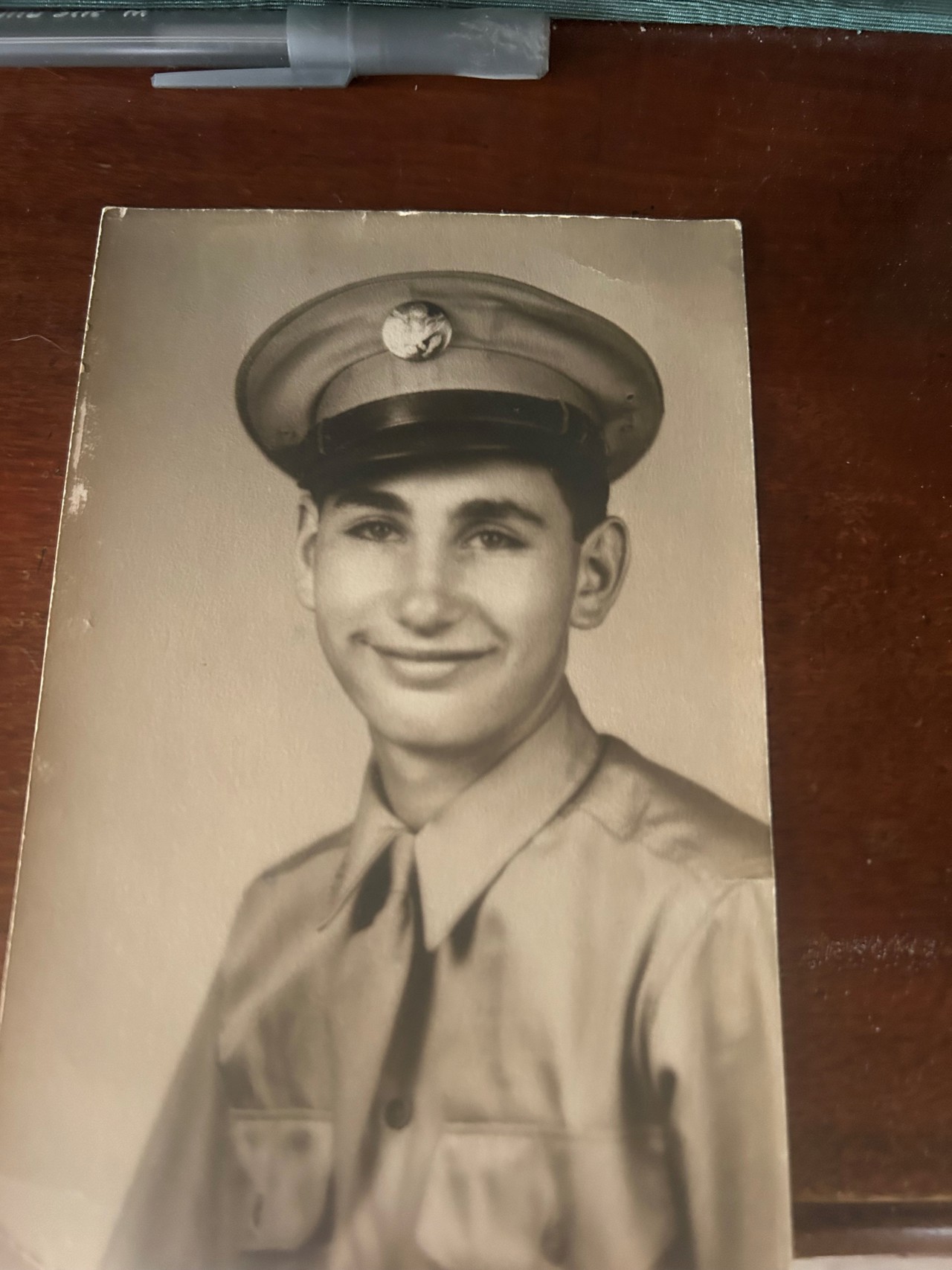 Black and white photo of smiling man in uniform.