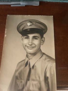 Black and white photo of smiling man in uniform.