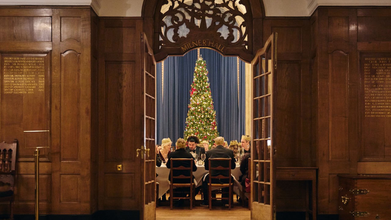 View of McCall MacBain Hall through the door from the vestibule, with Christmas party guests seated.