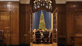 View of McCall MacBain Hall through the door from the vestibule, with Christmas party guests seated.