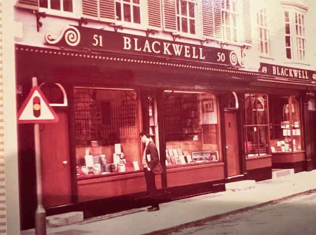 Man stood outside bookshop.