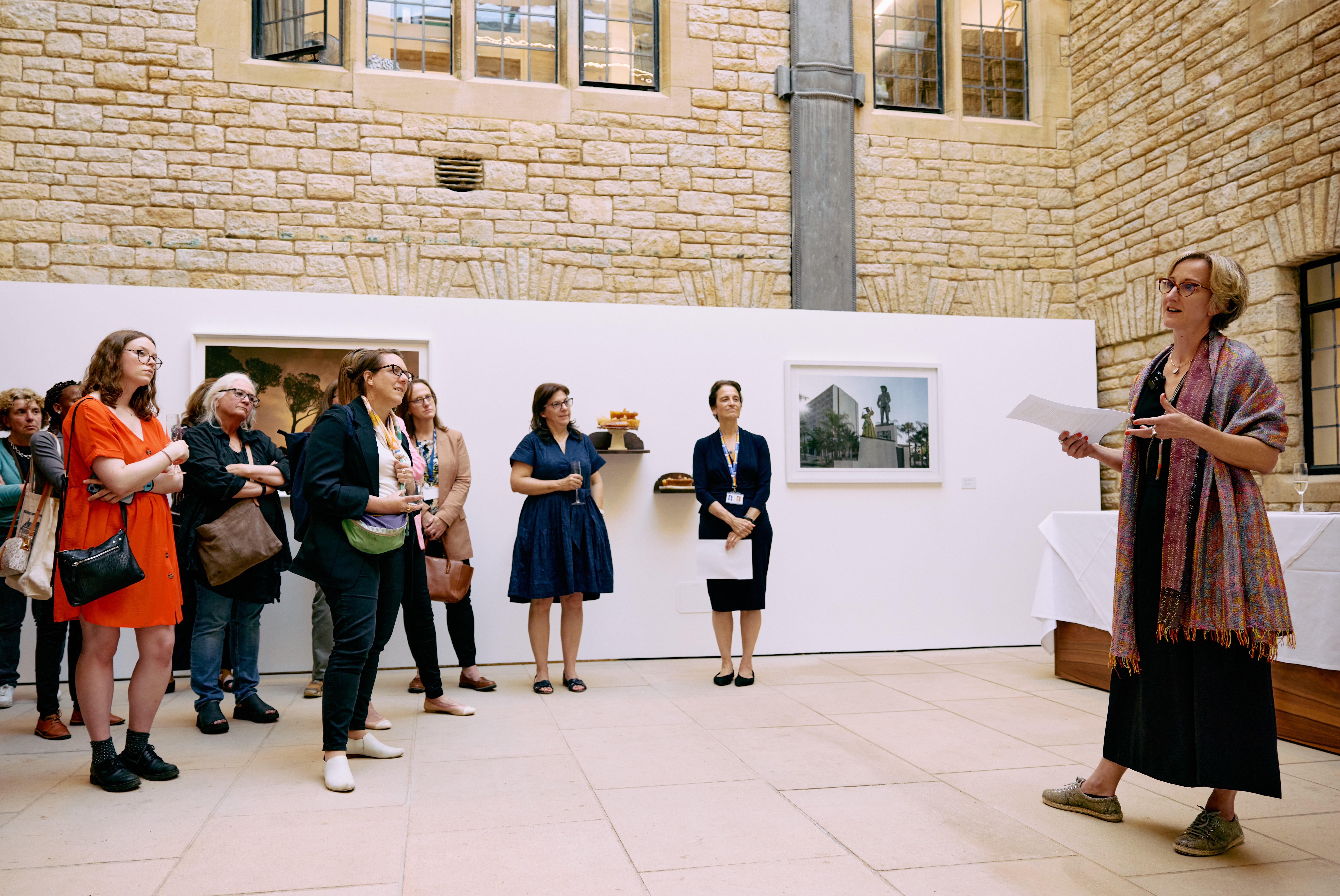 Julie Taylor addressing a group of people listening intently at the Entangled art exhibition launch