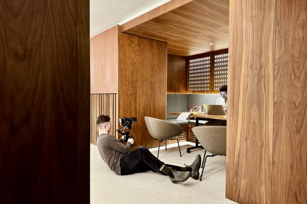 Person being filmed while working on a laptop and sitting in a nook in the Conference Foyer.