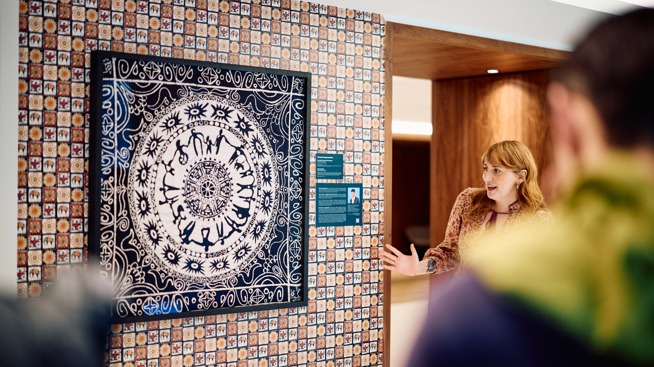 A woman discussing one of the artworks that features a batik design
