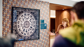 A woman discussing one of the artworks that features a batik design