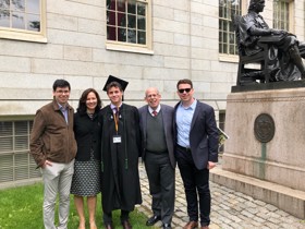 The picture shows the Grafstein family dressed smartly. Isaac Grafstein is wearing a graduation gown and to the right of this group is the statue of John Harvard.