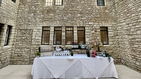 Lightwell with table set up for a drinks reception and blue skies visible through the glass ceiling.
