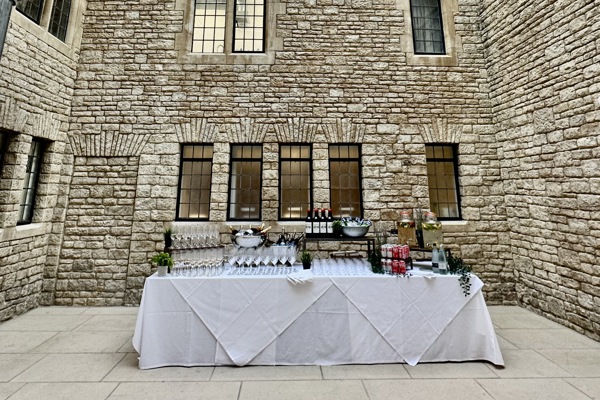 Lightwell with table set up for a drinks reception and blue skies visible through the glass ceiling.