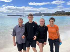 Elle, her children Zac and Tessa, and her husband Damian on a beach with the ocean behin them