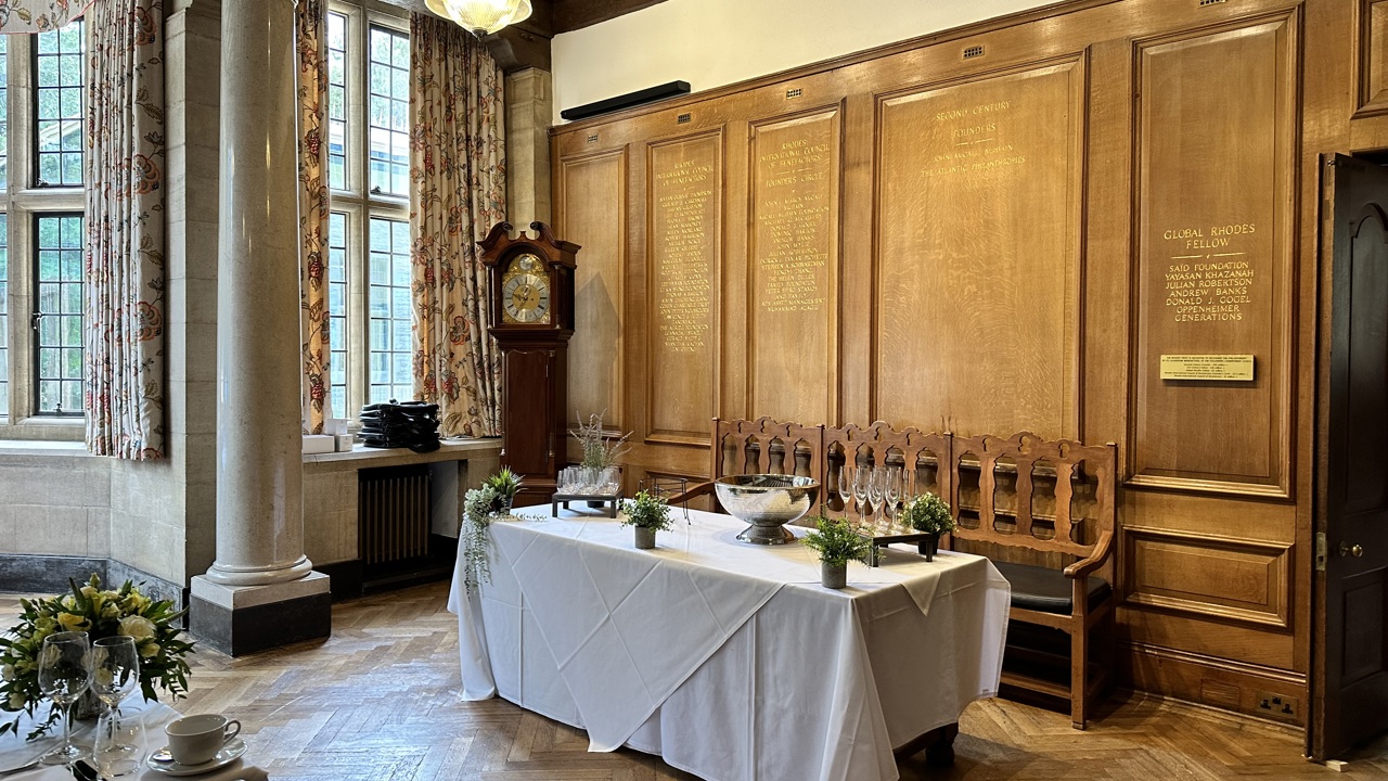 Wooden wall with gold engravings, and a table display before it.