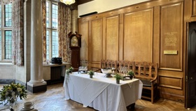 Wooden wall with gold engravings, and a table display before it.